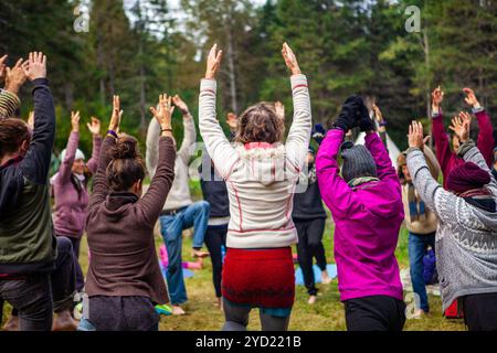 Un grand groupe de personnes sont considérées debout dans un cercle, levant les bras en l'air en effectuer des exercices spirituels lors d'une culture éclectique Banque D'Images