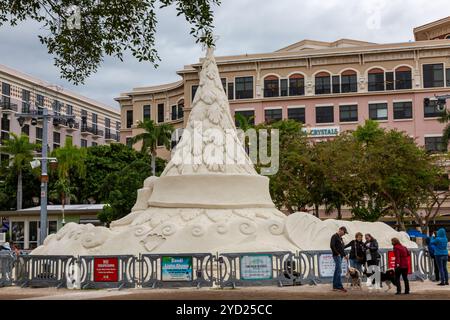 Des gens et leurs chiens près d'une sculpture de sable de Mark Mason et Team Sandtastic représentant un arbre de Noël dans le centre-ville de West Palm Beach, Floride, États-Unis. Banque D'Images