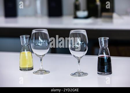 Deux petits mini décanteur ou des bouteilles remplies avec du rouge à côté de vins blancs et de verres vides, de verres à dégustation de vin décanteurs accessoires port Banque D'Images