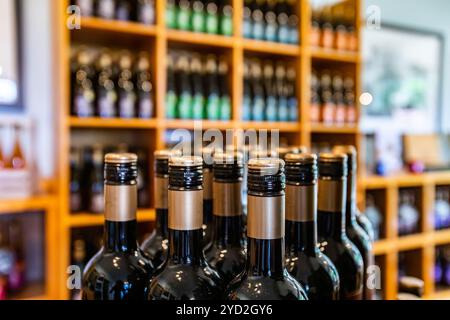 Beaucoup de bouteilles de vin en verre ambré foncé dessus, avec le joint du bouchon à vis en or, le cou, et l'épaulement de la bouteille libre focus sélectif contre les rayons vins Banque D'Images