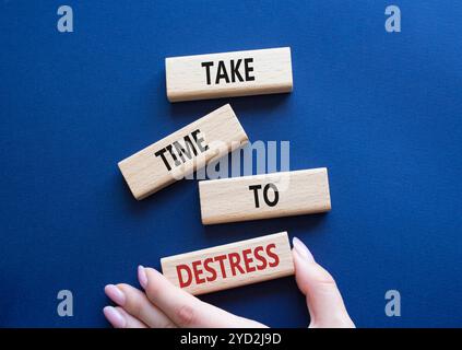 Symbole prendre le temps d'habiller. Les blocs de bois avec des mots prennent du temps à Destress. Beau fond bleu profond. Main d'homme d'affaires. Et prenez du temps Banque D'Images