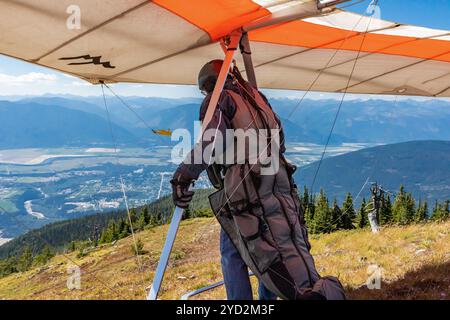 Deltaplane para-marin se préparant à descendre au-dessus des collines de la vallée de Kootenay, Creston, Colombie-Britannique, Canada Banque D'Images