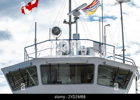 Gros plan sur le pont de commandement d'un ferry pour passagers. Drapeau canadien et instruments de navigation technique comme radar et sonar. Ciel nuageux. Banque D'Images