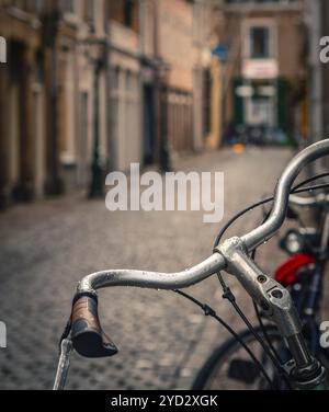 Scène d'une bicyclette sous la pluie dans une rue pavée Backstreet Européenne Banque D'Images