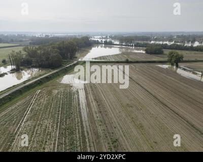 Vue aérienne d'un paysage agricole inondé avec des champs et une rivière débordant en raison de fortes précipitations. L'inondation cause des dommages aux récoltes et à la fa Banque D'Images