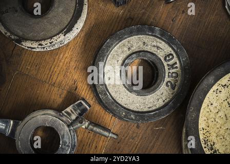 Détail de certains poids Vintage Gym Dumbbell contre Un plancher en bois rustique Banque D'Images