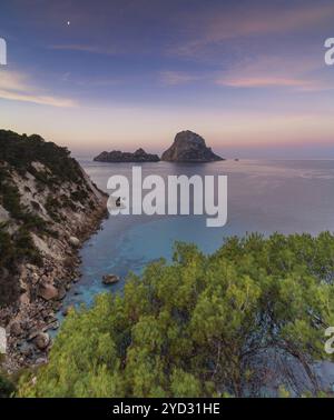 Une vue sur l'île emblématique es Vedra et les rochers au large de la côte d'Ibiza au lever du soleil Banque D'Images