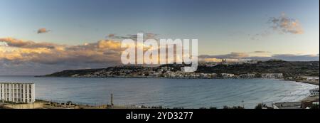 Une vue panoramique sur la baie de Mellieha à Malte au coucher du soleil Banque D'Images