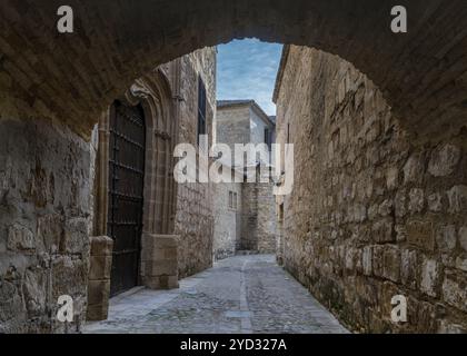 Baeza, Espagne, 5 avril 2024 : rue étroite et arc de pierre le long du chemin Paseo de las Murallas dans le centre historique de Baeza, en Europe Banque D'Images