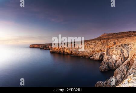 Vue sur les falaises et le rivage accidenté à Pont d'en Gil dans le nord-est de Minorque près de Ciutadella au coucher du soleil Banque D'Images