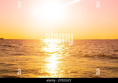 Coucher de soleil en mer. Chaud coucher de soleil ensoleillé sur la mer. Vagues de mer. Le soleil se couche sur l'horizon. Le golfe de Finlande Banque D'Images