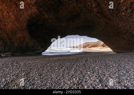 Une vue sur la plage et l'arc rocheux à Legzira sur la côte atlantique du Maroc Banque D'Images