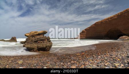 Une vue panoramique sur la plage et l'arc rocheux à Legzira sur la côte atlantique du Maroc Banque D'Images