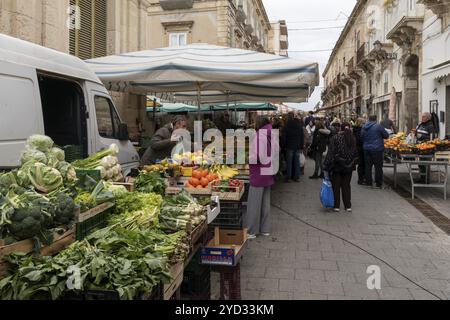 Syracuse, Italie, 28 décembre 2023 : Greengrocer vend des fruits et légumes à des clients sur le marché de Syracuse, en Europe Banque D'Images