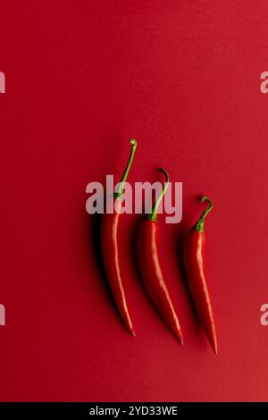 Piments Chili parfaitement composés sur dos rouge Banque D'Images