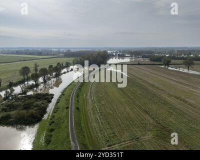 Vue aérienne d'un paysage agricole inondé avec des champs et une rivière débordant en raison de fortes précipitations. L'inondation cause des dommages aux récoltes et à la fa Banque D'Images