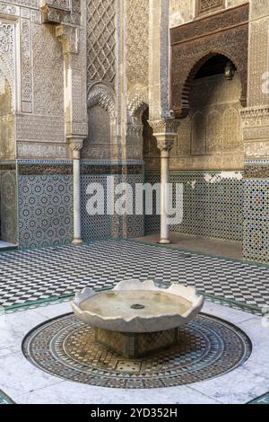 Fès, Maroc, 4 mars 2024 : fontaine et cour de l'école de parfumeurs Al-Attarine Madrasa dans le centre de Fès, en Afrique Banque D'Images