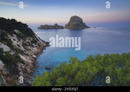 Une vue sur l'île emblématique es Vedra et les rochers au large de la côte d'Ibiza au lever du soleil Banque D'Images