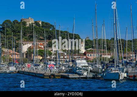 France, Porquerolles, 9 juin 2024 : bateaux dans le port de l'île de Porquerolles, et Fort Sainte Agathe Banque D'Images