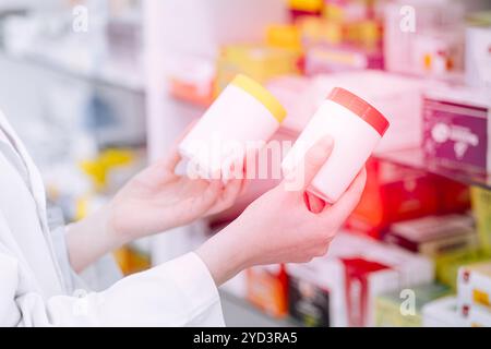 Pharmacien médecin tenant deux bouteilles de médecine comparer la sélection ou le choix danger de médecine stéroïde dans la pharmacie de pharmacie. Banque D'Images