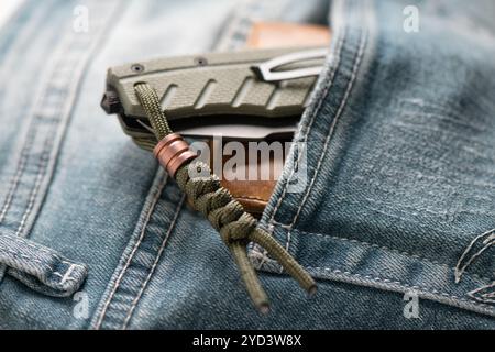 Gros plan longe verte avec perle en alliage de titane sur couteau pliant vert. Banque D'Images