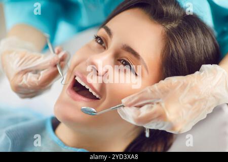 Portrait d'une patiente à bouche ouverte lors de l'examen avec outils dentaires en clinique dentaire. Banque D'Images