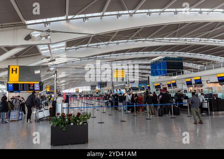 Inside terminal 5 départs à l'aéroport de Londres Heathrow, Royaume-Uni. Passagers en file d'attente à l'enregistrement des bagages pour les vols British Airways. Comptoirs d'enregistrement de la zone H. Banque D'Images