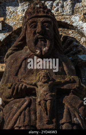 Statue de Dieu le Père tenant Christ sur la croix. Sur le porche sud de l'église Saint nonne, Dirinon, Finistère, Bretagne, France. Le porche sud est daté de 1618 et la statue est immédiatement en dessous de la date. Banque D'Images