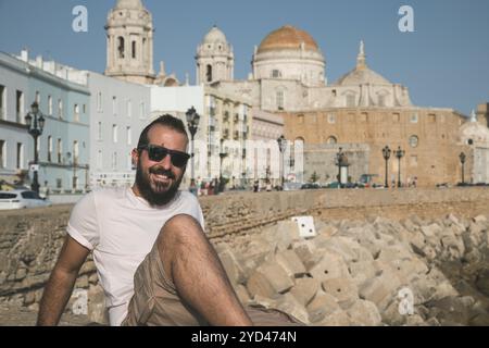 homme d'âge moyen souriant devant une ville antique Banque D'Images