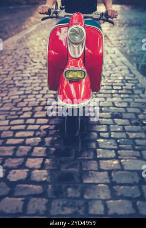Homme à cheval sur un scooter italien Banque D'Images