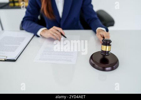 Avocat se préparant à signer un contrat et marteau en bois sur la table justice et concept de droit Banque D'Images