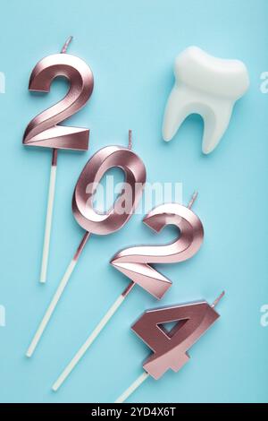 Figure 2024 et dent avec décoration de Noël sur fond bleu. Vue de dessus Banque D'Images