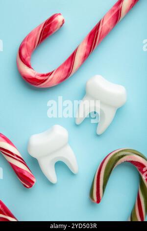 Odontologie. Vacances de Noël. Figurine de dent avec des bonbons sur fond bleu. Vue de dessus Banque D'Images