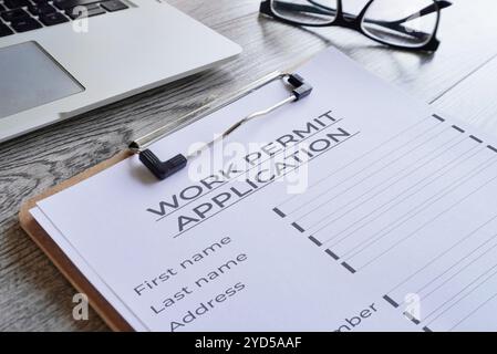 Gros plan de presse-papiers avec formulaire de demande de permis de travail sur table en bois. Banque D'Images