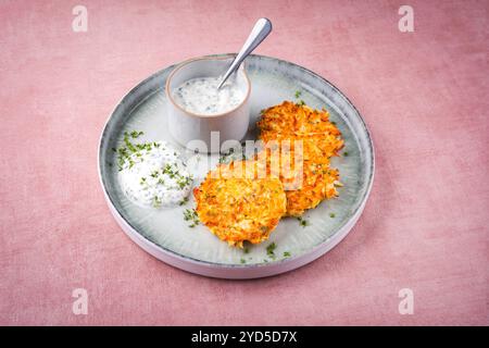 Crêpes de pommes de terre au panais traditionnelles avec ciboulette et sauce au fromage blanc servies en gros plan sur une assiette Nordic Design avec espace texte Banque D'Images