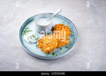 Crêpes de pommes de terre au panais traditionnelles avec ciboulette et sauce au fromage blanc servies en gros plan sur une assiette Nordic Design avec espace texte Banque D'Images