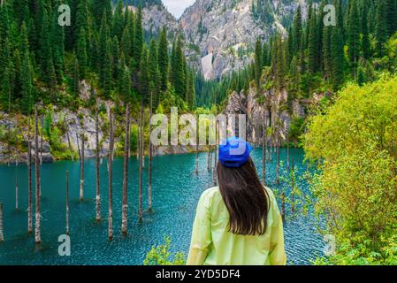 Jeune femme debout contre un paysage de montagne pittoresque. Lac Kaindy, Kazakhstan, Parc national des lacs de Kolsay Banque D'Images