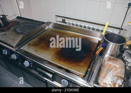 Surface argentée de la plaque chauffante chaude de restaurant de cuisine professionnelle en acier inoxydable. Griddle dans la cuisine professionnelle dans le restau Banque D'Images