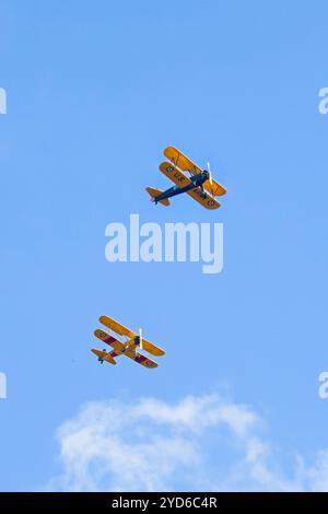 Deux biplans de style ancien volant en formation dans le ciel lumineux près de Liberty Lake, Washington. Banque D'Images