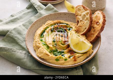 Délicieux houmous maison avec citron, paprika, huile d'olive et microgreens. Plat végétarien du moyen-Orient Banque D'Images