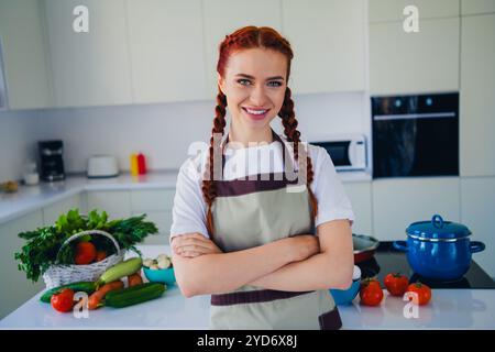 Photo d'adorable jolie fille portant tablier cuisine repas maison à l'intérieur Banque D'Images