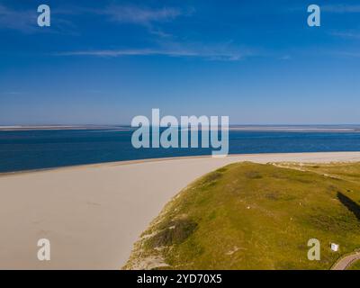 Une vue aérienne captivante de Texel, aux pays-Bas, mettant en valeur une plage tranquille avec des vagues ondulantes et la vaste étendue bleue de l'océan Banque D'Images