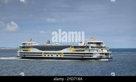 Un grand ferry glisse gracieusement à travers la vaste étendue de l'océan, laissant une traînée d'écume blanche dans son sillage. Le ferry Banque D'Images