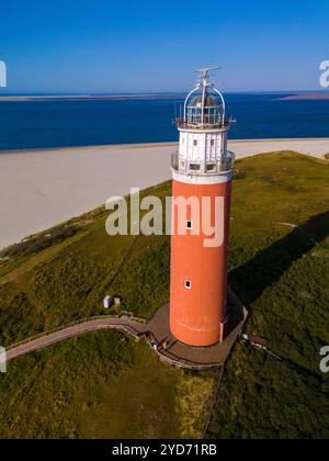 Une perspective aérienne d'un pittoresque phare blanc debout fièrement sur les rives sablonneuses de Texel, pays-Bas, surplombant Banque D'Images