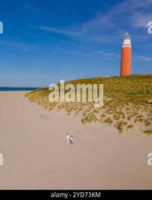 Une vue aérienne d'un majestueux phare debout sur la plage de Texel, aux pays-Bas, entouré de sable doré et de soothin Banque D'Images