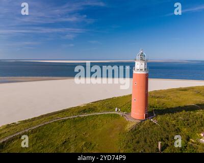 Une vue aérienne capture un majestueux phare perché sur une plage de sable à Texel, aux pays-Bas, fournissant une lumière de guidage aux navires Banque D'Images