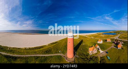 Une perspective aérienne d'un phare debout haut sur la plage de sable de Texel, surplombant la vaste étendue de l'océan avec Banque D'Images