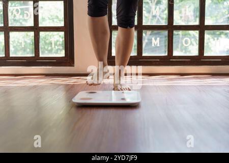 Régime gras et pieds de balance debout sur des balances électroniques pour le contrôle du poids. Instrument de mesure en kilogramme pour un contrôle de régime Banque D'Images
