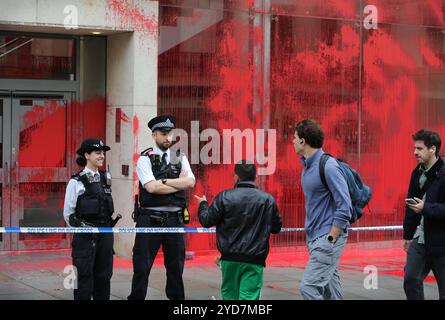 Londres, Angleterre, Royaume-Uni. 25 octobre 2024. Les membres de la promenade publique parlent aux policiers sur le cordon à l'extérieur des bureaux de l'APCO, l'extérieur du bâtiment est recouvert de peinture rouge. Les activistes bloquent les entrées des bureaux d'APCO dans le Strand pour la deuxième fois en un mois à Londres, s'attachant à un verrou de valise, après avoir pulvérisé l'extérieur du bâtiment avec de la peinture rouge sang. APCO est embauché par Elbit Systems pour faire pression sur les politiciens en leur nom. Palestine Actionists continuent de prendre des mesures directes contre les entreprises qui permettent à la société israélienne d'armement Elbit Systems d'opérer dans le Banque D'Images