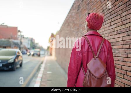 Gen z fille mode en cuir avec punk asiatique femme touriste de la ville locale Asie du Sud-est voyage tendance coiffure rose jeune femme Banque D'Images